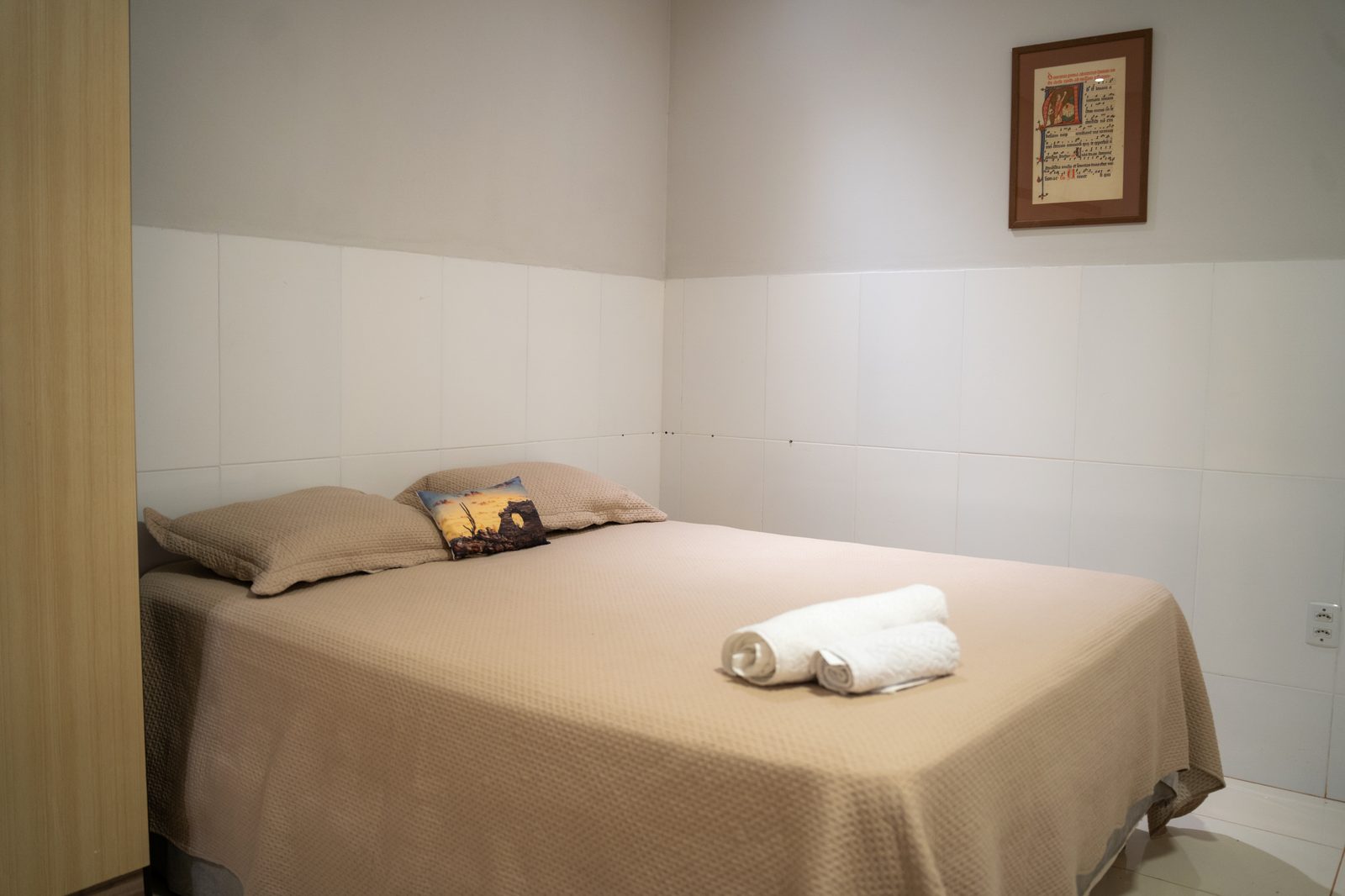 Quarto com cama de casal, roupa de cama e toalhas